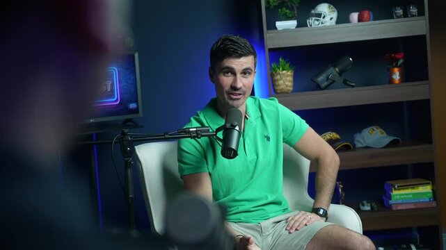 Young man speaking during podcast interview in modern recording studio, swinging circular hand motions as he talks