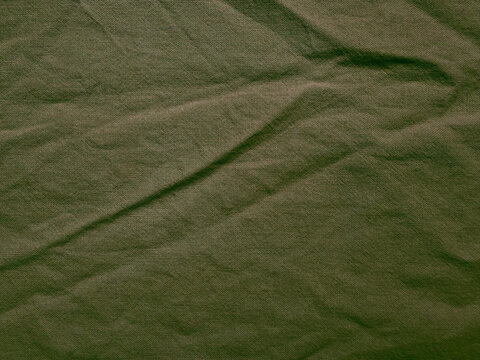 olive green crumpled linen fabric texture background with organic folds and rustic sustainable textile material aesthetic