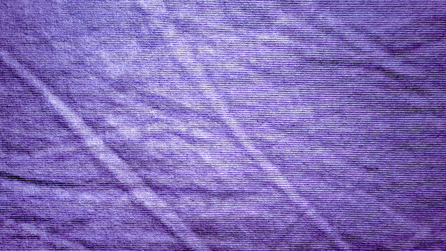 textured purple cotton fabric with natural creased folds and subtle ribbed lines creating an organic textile background