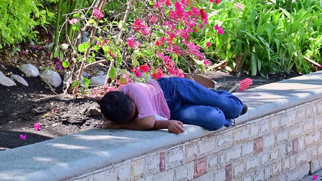 Latina girl lying in the park hugging her stuffed animal