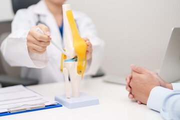Doctor with Human Knee joint anatomy model. Osteoarthritis, Patellofemoral Pain Syndrome, Patellar...