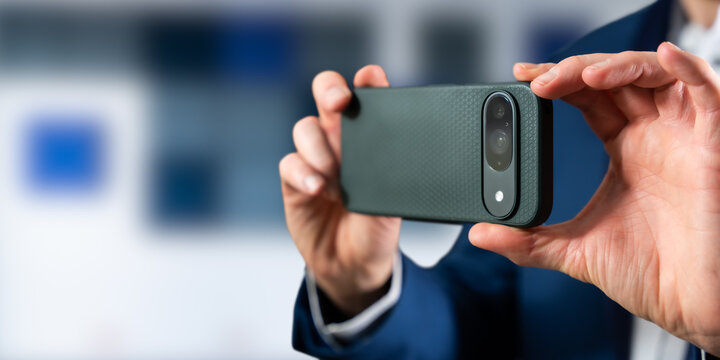 Businessperson Holding Smartphone Camera Horizontally in Office, Taking Photo or Video Close-Up