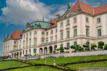 Obraz premium Royal Castle Facade and Terraced Gardens Under Dramatic Sky