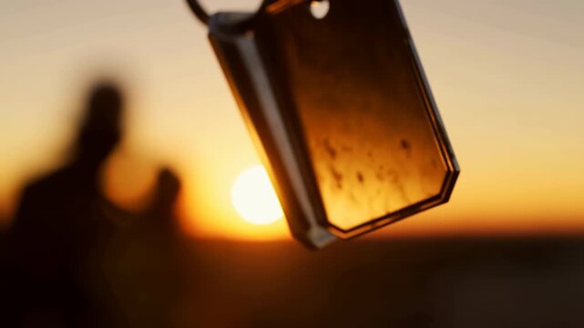 Metal wind chimes silhouetted at sunset