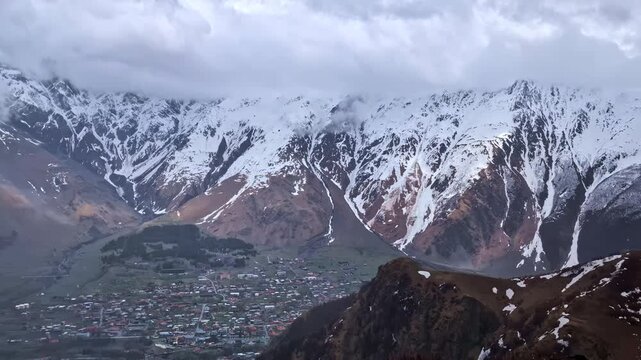 Mountain town of Stepantsminda in Georgia Caucasus Mountains snow covered peak landscape