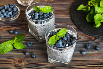 Healthy breakfast or morning with chia seeds vanilla pudding and blueberry berries on table background, vegetarian food, diet and health concept. Chia pudding with coconut milk and blueberry © sosiukin
