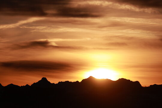The sun is setting behind a mountain range