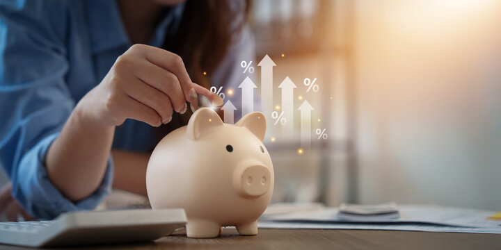 Woman putting coin into piggy bank for financial saving and investment