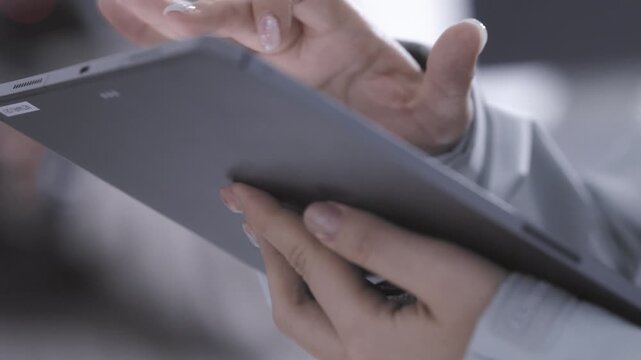 Low Angle View of Female Crew Hands Holding and Operating Digital Tablet Screen on Set
