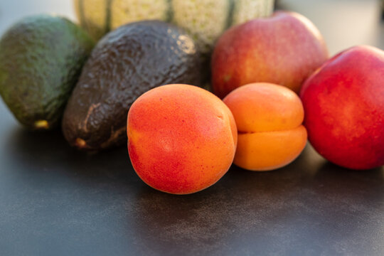 Frisches Arrangement mit Melone, Avocado und gesunden Zutaten auf dunklem Hintergrund
