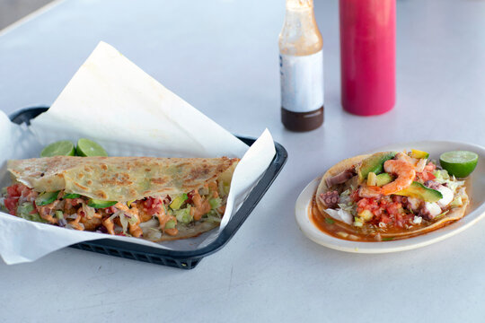 Delicious mariscos tostada and quesadilla on white table