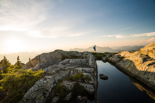 Man hiking on a scenic mountain ridge at sunset