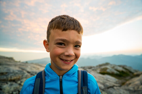 Happy young boy smiling on a mountain hike