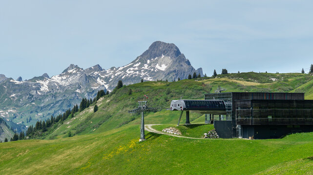 Ski lift valley station near Lech am Arlberg, mountain railway in spring on a blooming alpine meadow, many different alpine flowers form a colorful pasture for the cows