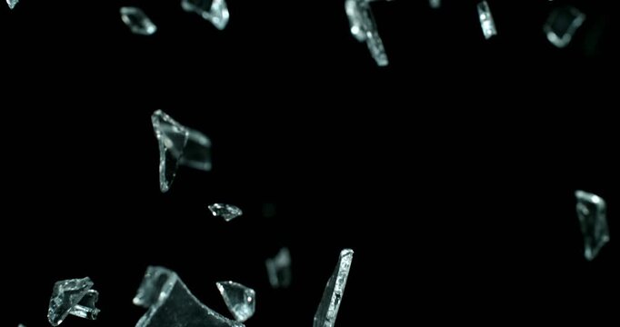 Glass shards exploding and scattering in ultra slow motion at 1000 fps. High-detail fragments suspended in air, creating dramatic cinematic impact visuals.