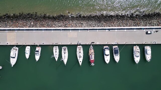 Aerial top down view of small fishing boats moored at the pier in harbor