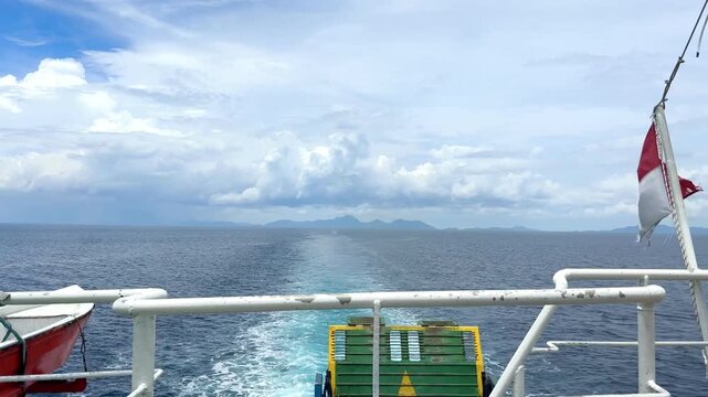 Indonesian flag waving on passenger ferry deck with ocean wake footage. Perfect for commercial travel videos, maritime transport promos, and Indonesian tourism vlogs.