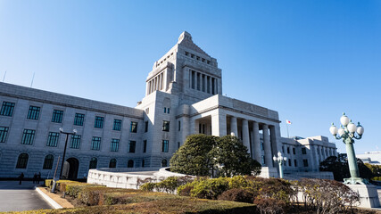 美しい青空の下にそびえ立つ日本の政治の中心・国会議事堂の重厚な外観風景 © apiox