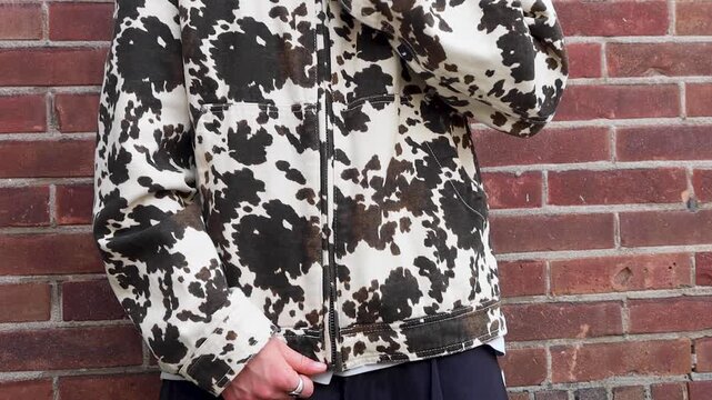 Video of a person pulling zipper of his jacket down and walking away.