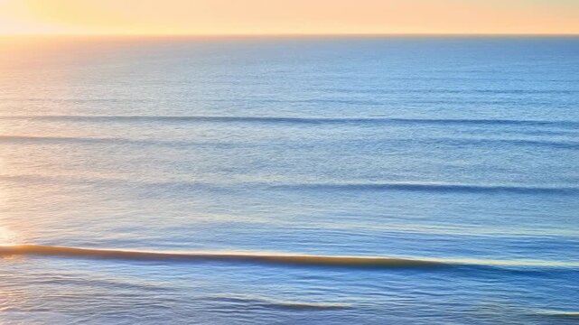 Calm sea surface with gentle parallel ripples at sunrise