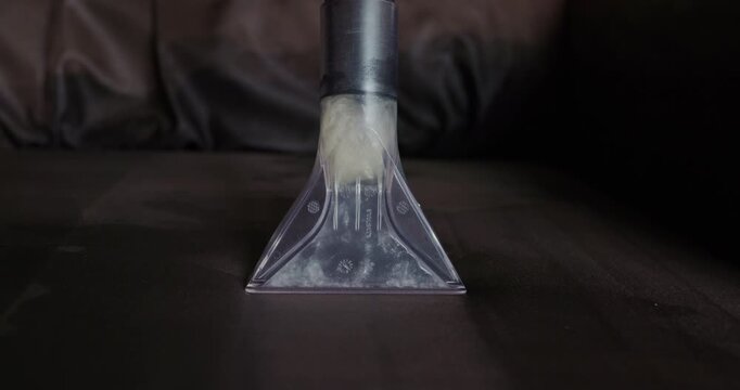 Professional chemical cleaning of upholstery couch with extractor machine