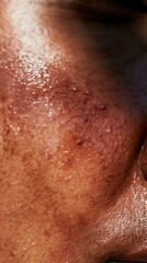Fototapeta premium Dewy skin texture of a person with deep brown complexion, featuring glowing reflections and visible pores for skincare and dermatology branding