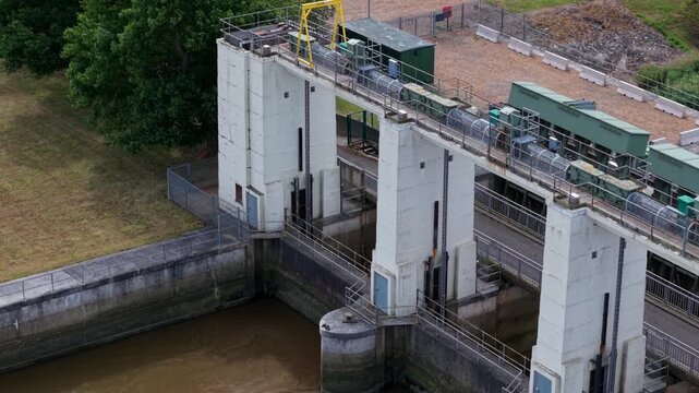 Close up drone view of a tidal flood defence asset and civil engineering water control sluice gates, tail sluice near Kings Lynn, UK.