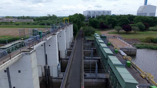 Close-up aerial view of a massive tidal outfall barrier and coastal drainage infrastructure for regional water control in Kings Lynn, UK.