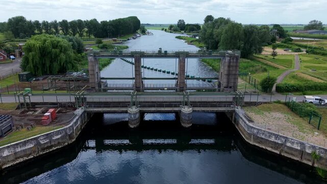 Close-up aerial view of a massive tidal outfall barrier and coastal drainage infrastructure for regional water control in Kings Lynn, UK.