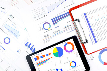 Obraz premium Financial data analysis dashboard on tablet and paperwork. Corporate business report, marketing growth strategy, and investment ROI statistics concept. Overhead view.
