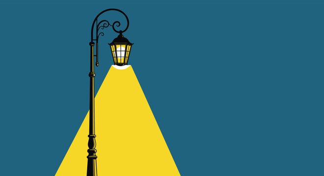 Vintage wrought iron street lamp casting a bright yellow beam of light against a dark blue evening background at night.