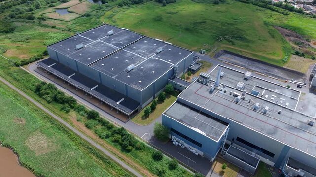 High aerial view of a massive industrial manufacturing plant with steam venting from chimneys in the UK.
