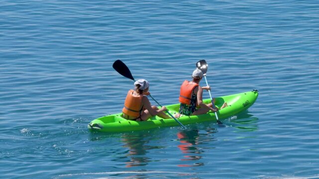 Two People Paddling a Green Kayak in the Ligurian Sea