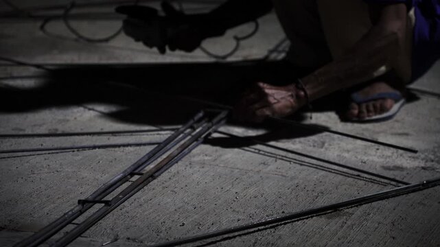 Angle Grinder Grinding Metal Rods With Sparks on Concrete Floor