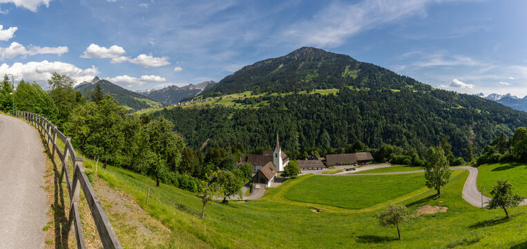 St. Gerold Monastery in the Grosswalsertal valley, Austria, lies in the valley on a flowering meadow, with wooded slopes and mountains in the background. Cultural events and seminars are held inside
