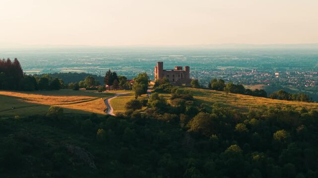 Aerial shot revealing Essalois Castle, Saint Just Saint Rambert city ans the Loire river in the background in the Plaine du Forez at sunset, Loire departement, Auvergne RHone Alpes region, France