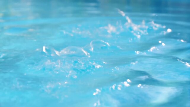 Close-up of water splashes in a swimming pool. Capturing the refreshing essence of summer fun and relaxation in aquatic environments