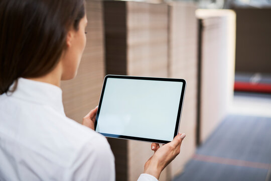 Close-up of woman using tablet in a factory warehouse