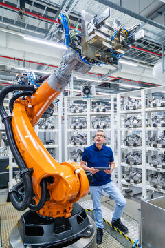 Engineer operating industrial robot in automated factory environment