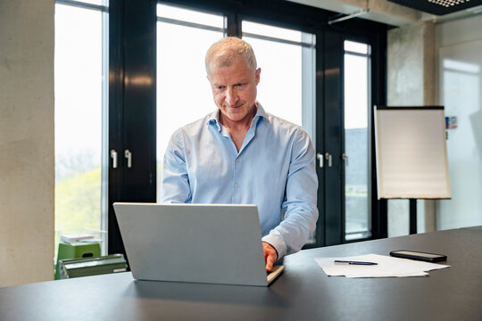 Business executive working on laptop in modern office