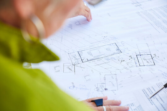 Architect pointing at building floor plan during business planning