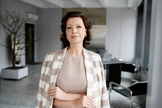 Confident businesswoman standing in modern corporate office