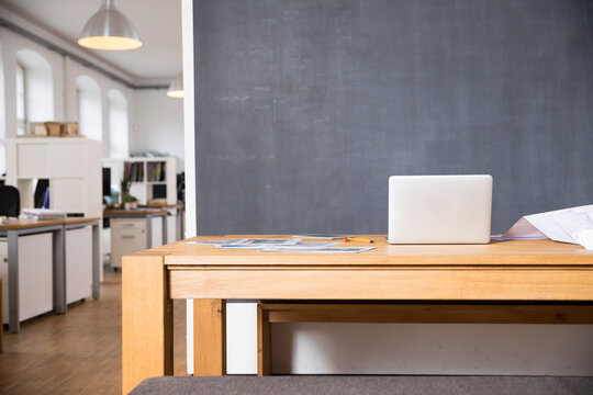 Laptop on desk in empty office