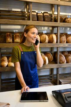 Business owner taking order on mobile phone in bakery shop