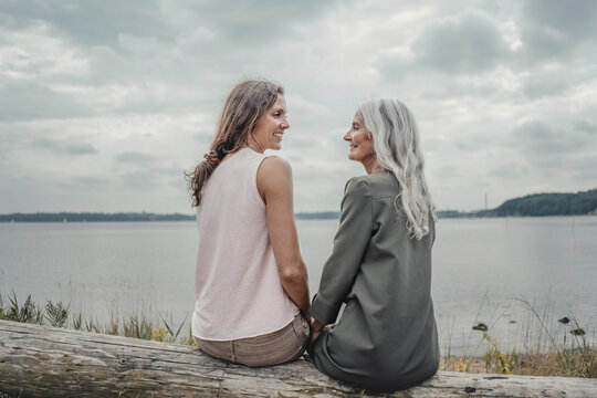 Mother and daughter talking on the beach