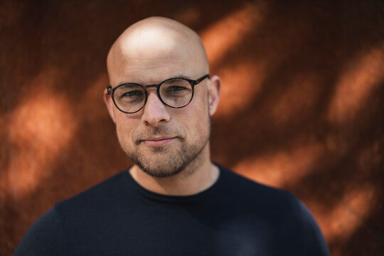 Portrait of bald man with beard wearing glasses