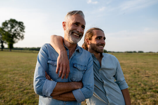 Happy father with adult son on a meadow in the countryside