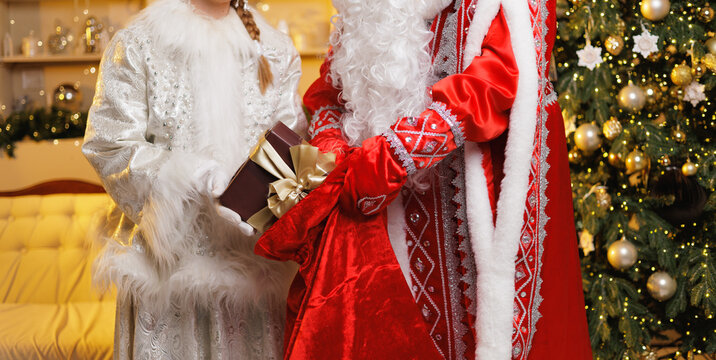 Ded moroz and snegurochka celebrating the festive season with gift giving