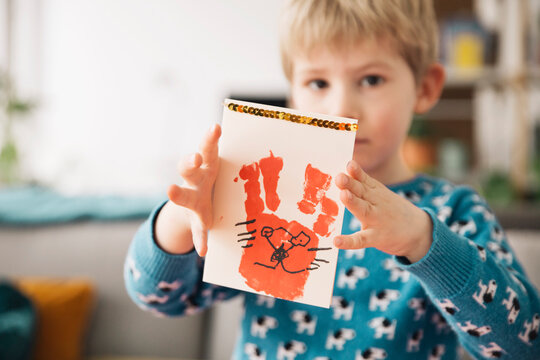 Little boy presenting self-made Easter card