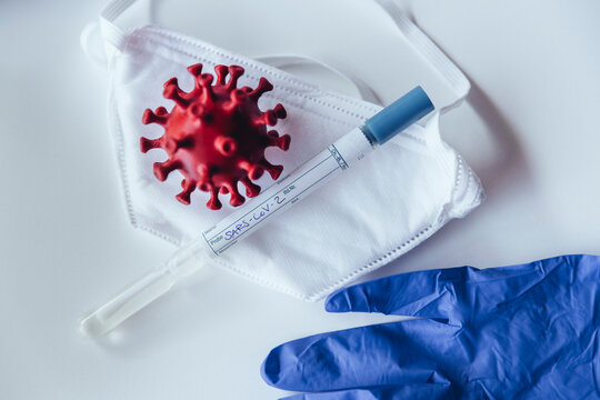 Model of corona virus with test kit on medical mask